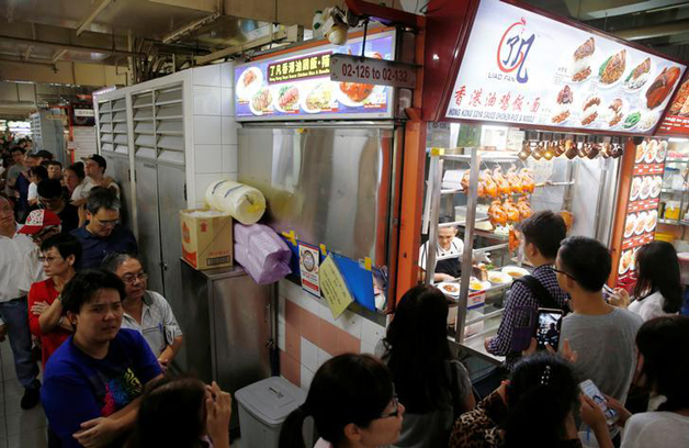 People queue outside hawker Chan Hong Meng's Michelin star awarded stall, for his soya sauce chicken rice and noodle at a food market in Singapore, July 22, 2016. REUTERS/Edgar Su